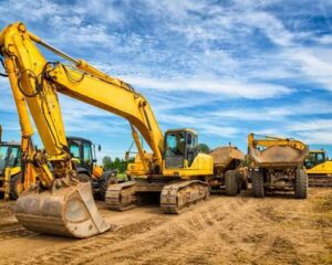 Yellow excavators and heavy equipment at construction site in early morning light for fleet expansion financing article